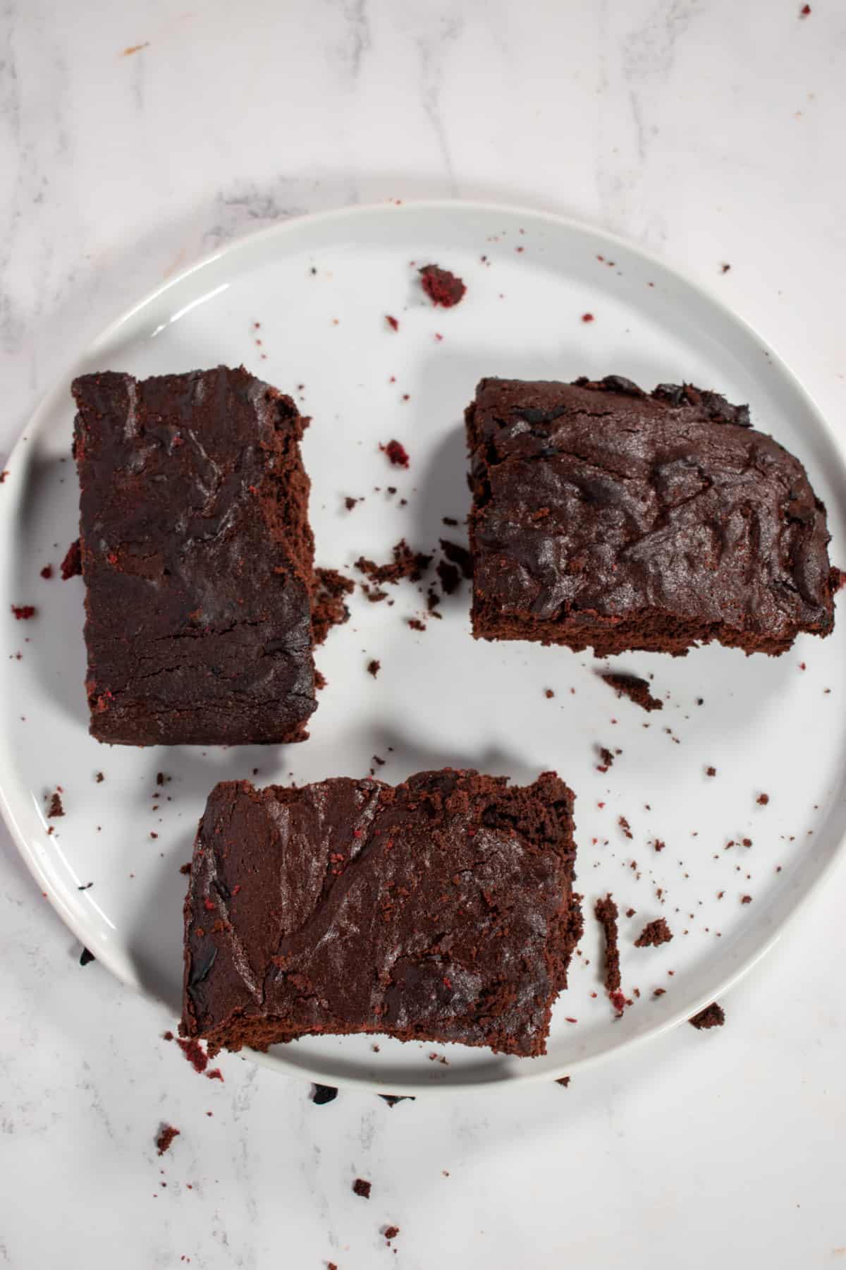 Three brownies on a white plate. 