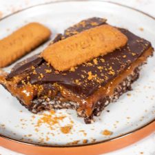 A large vegan caramel bar on a brown and white plate.