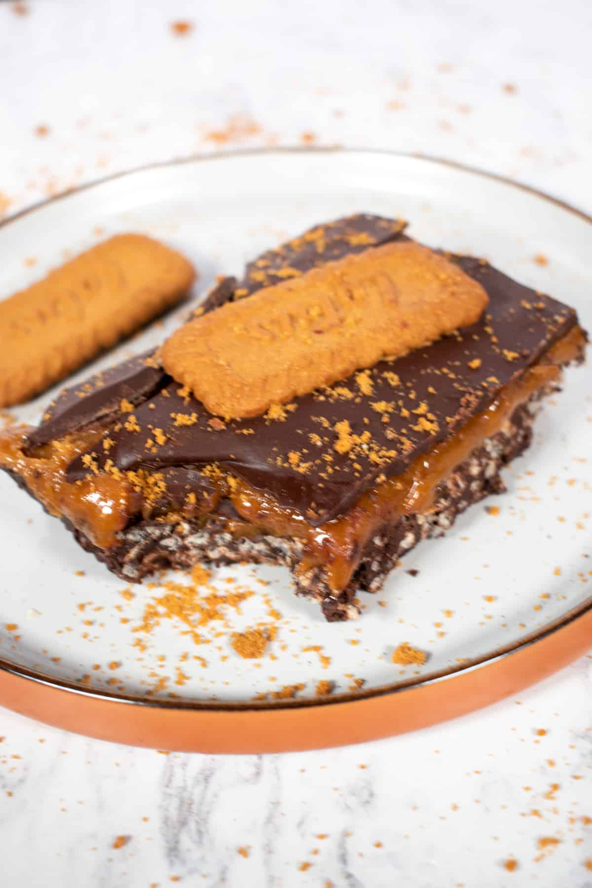 A large vegan caramel bar on a brown and white plate.