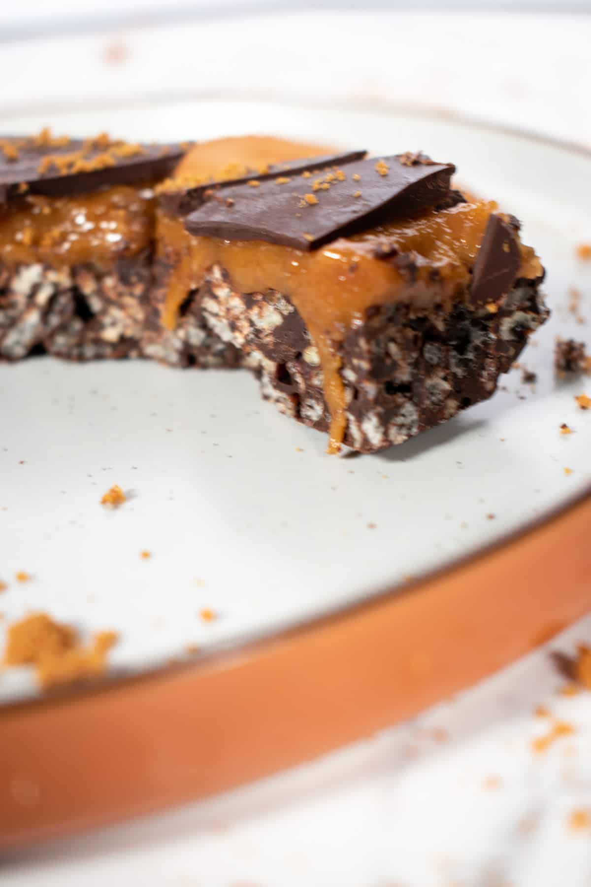 A single vegan caramel bar on a brown and white plate.