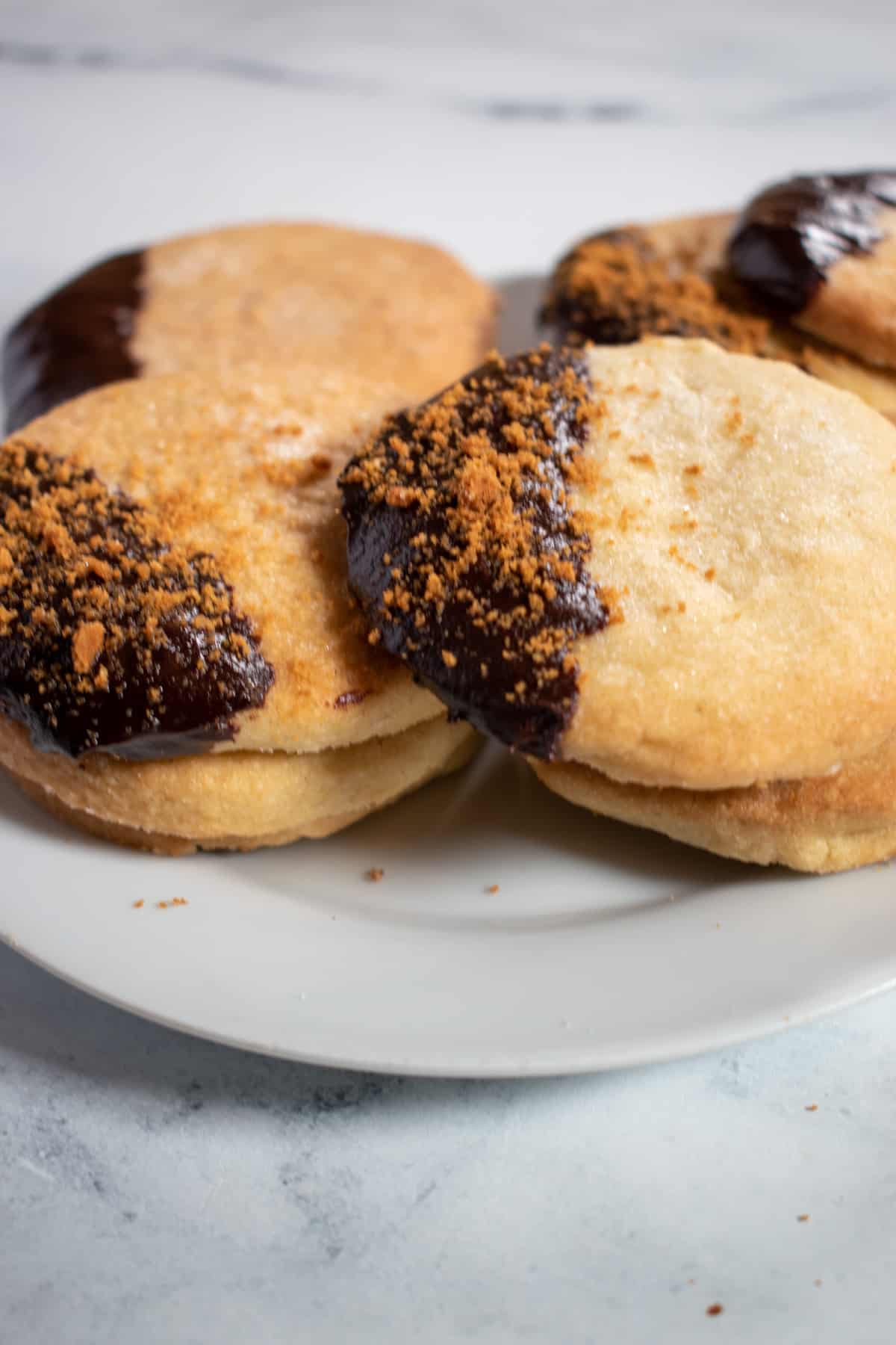 A collection of vegan chocolate shortbread biscuits on a white plate.