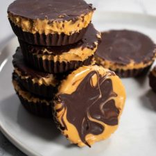 A stack of vegan chocolate peanut butter cups on a white plate.