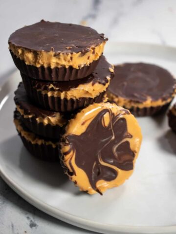 A stack of vegan chocolate peanut butter cups on a white plate.
