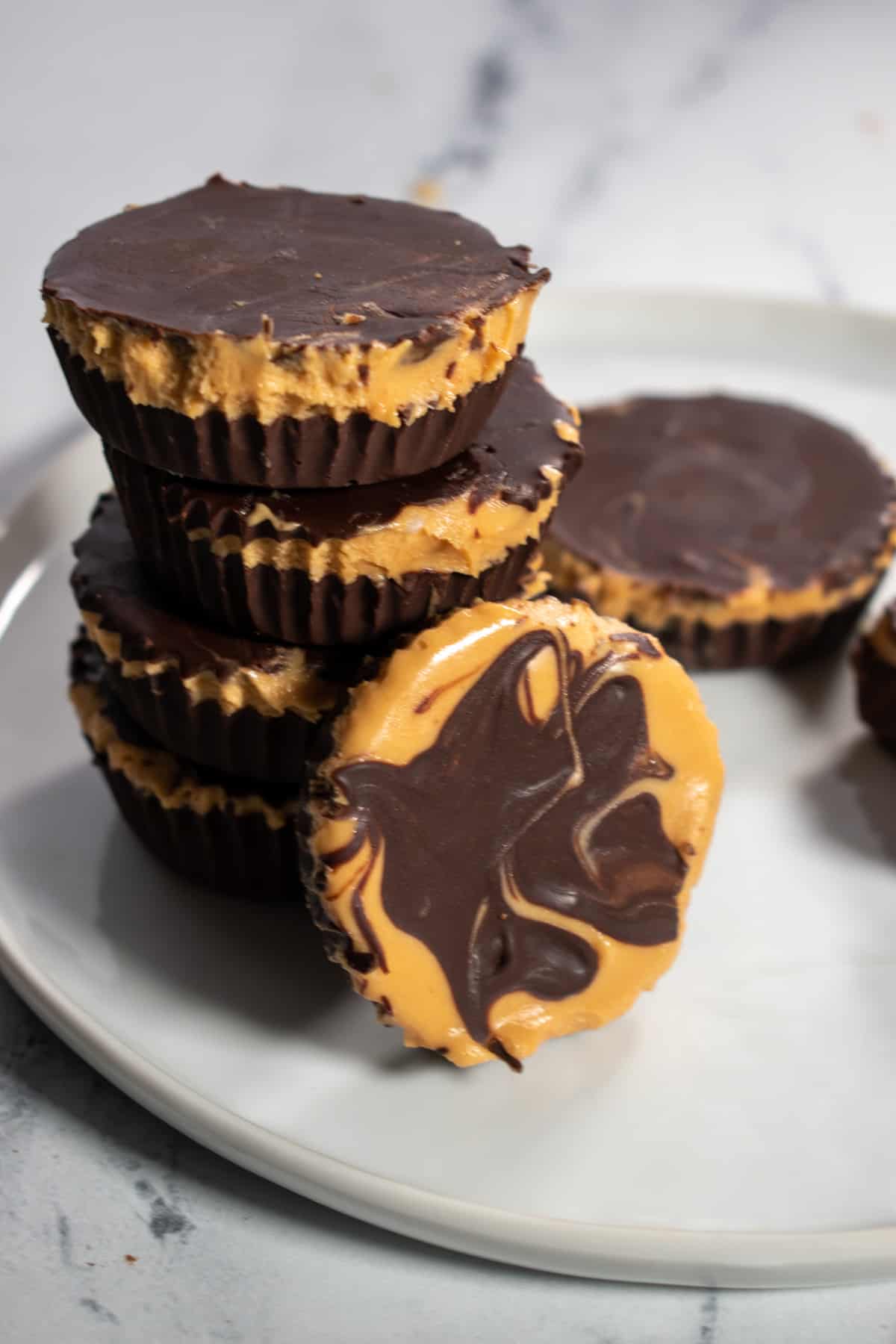 A stack of vegan chocolate peanut butter cups on a white plate.