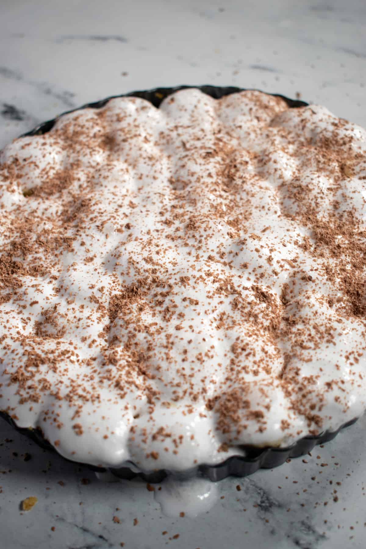 An aerial shot of a whole banoffee pie inside the springform tray. 