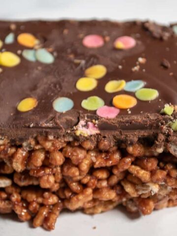 A close up shot of a rice krispie treats bar. Colourful sprinkles on top.