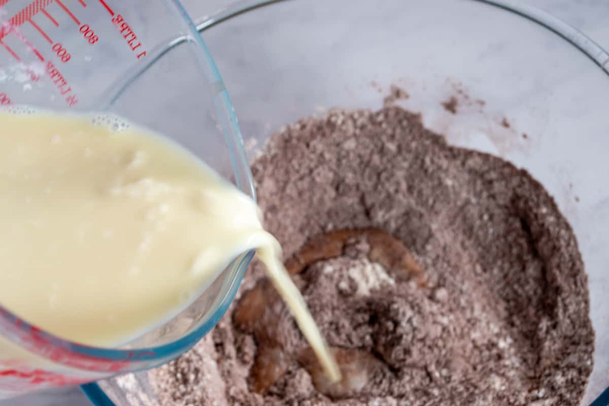 A photo of the curdled soy milk being added to the dry ingredients.