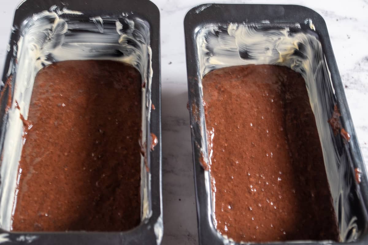 A photo of the eggless red velvet cake batter in the cake pans.