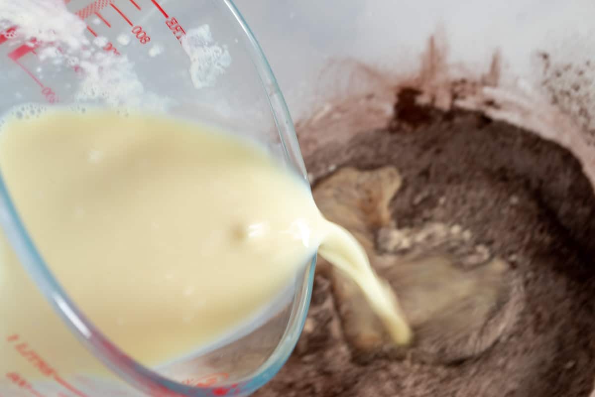 A photo of the curdled soy milk being added to the dry ingredients.