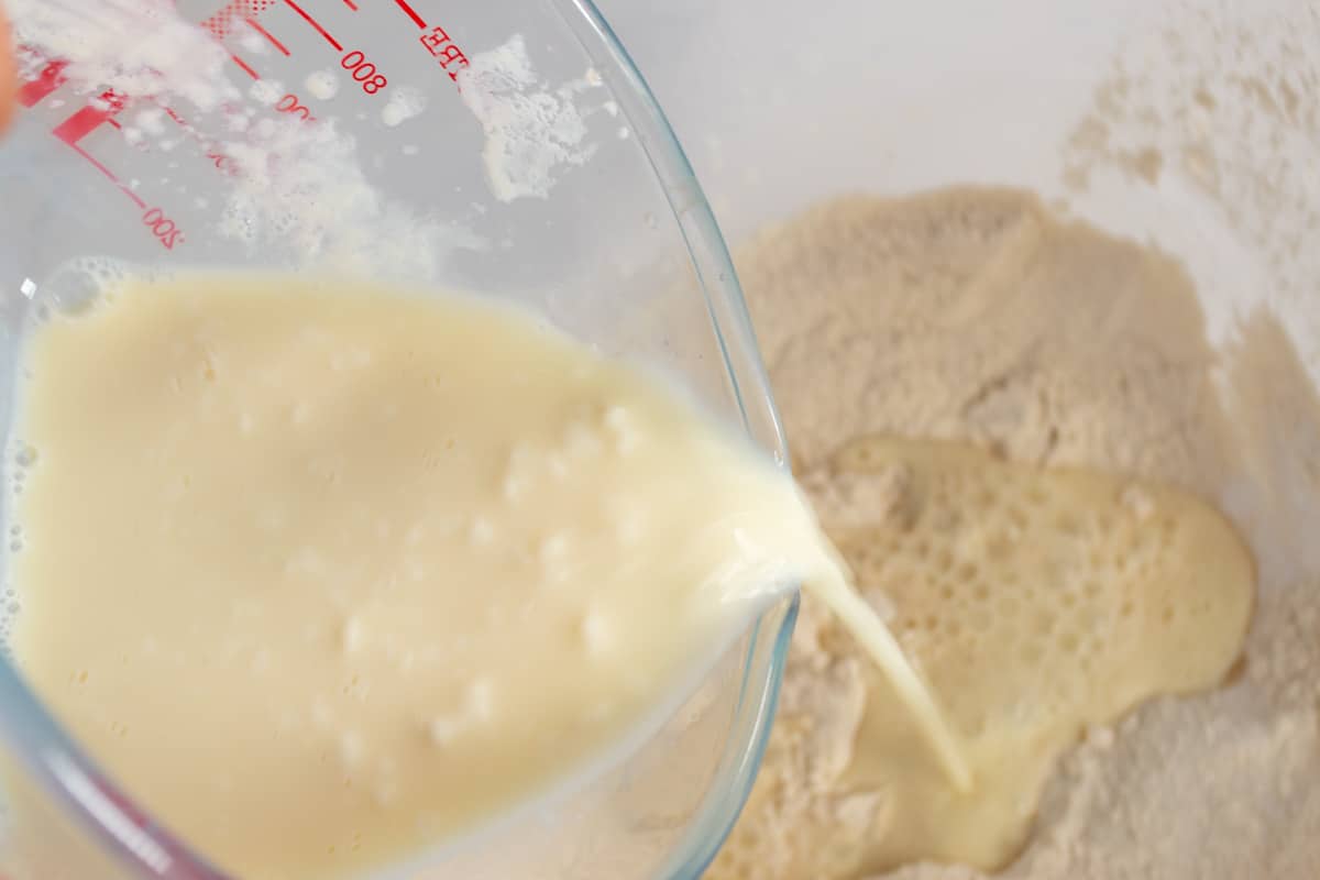 A photo of the curdled soy milk being added to the dry ingredients.