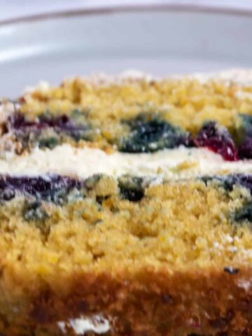 A thick slice of my eggless orange blueberry cake with vanilla buttercream.