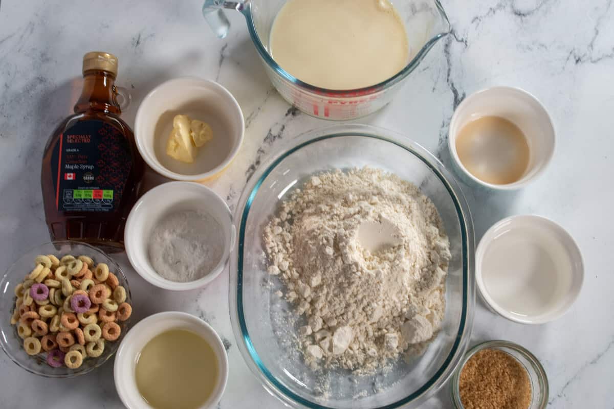 The ingredients needed to make vegan brown sugar pancakes laid out neatly over a white, marble background.