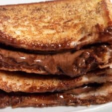 A zoomed in shot of my vegan chocolate french toast. A slice is stacked on top of another one. Chocolate is oozing out of both.