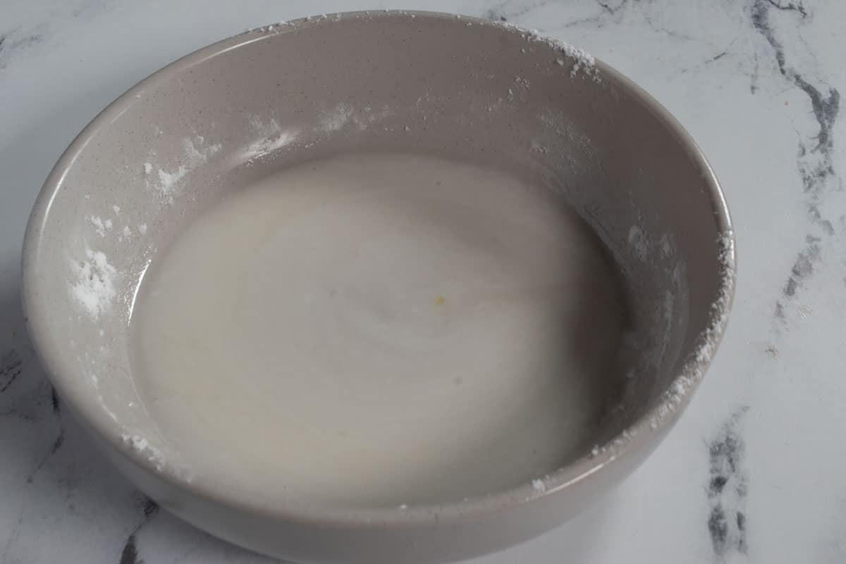 The glaze for the cake, in a grey bowl.