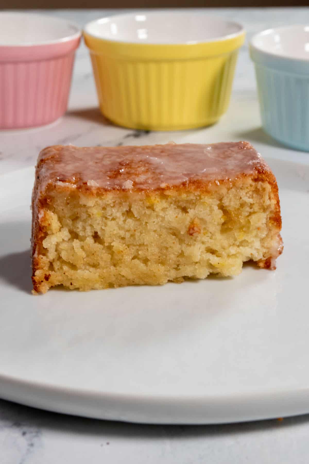 A close up piece of lemon drizzle cake. Moist. 