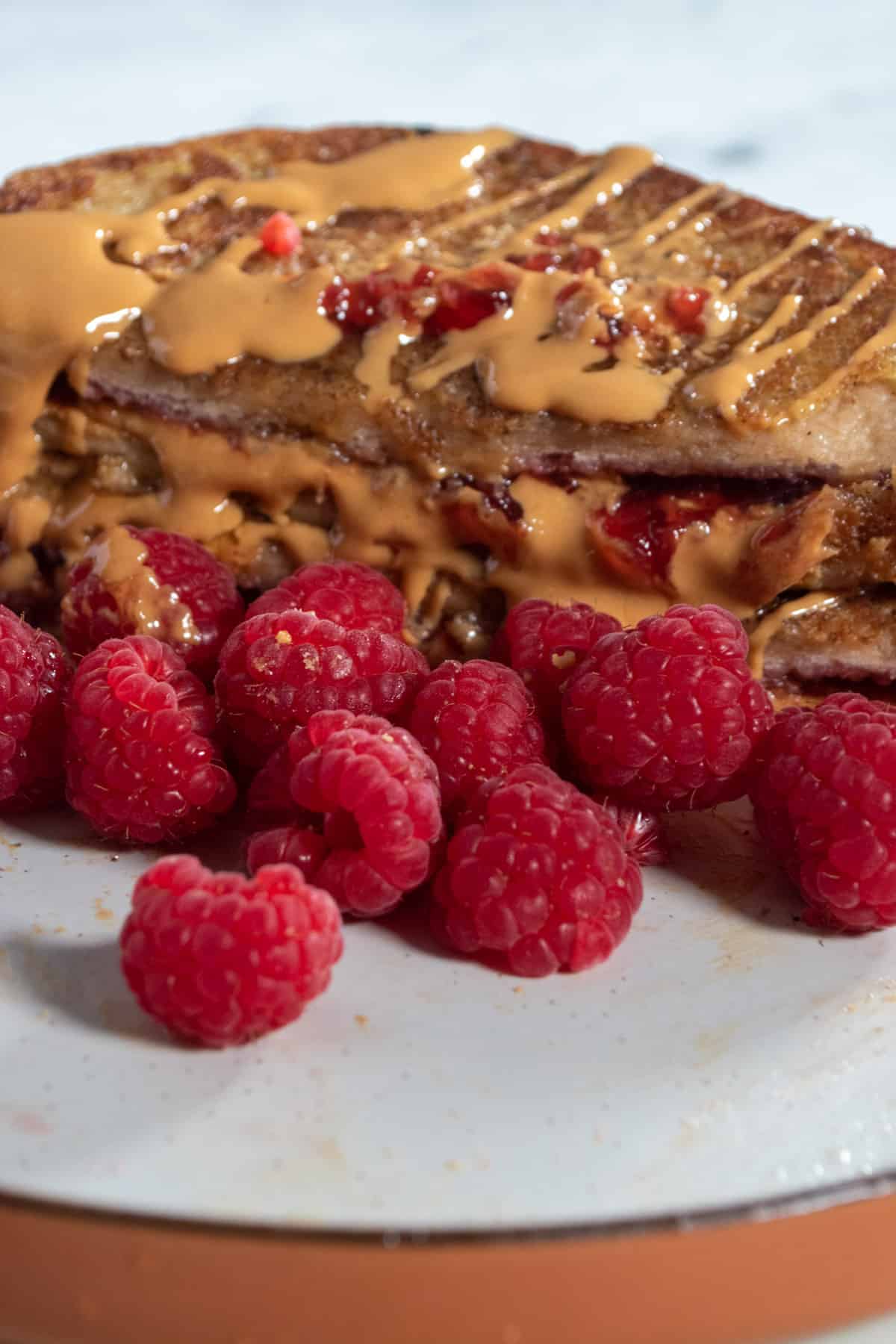 A low shot of the french toast. Lots of raspberries.