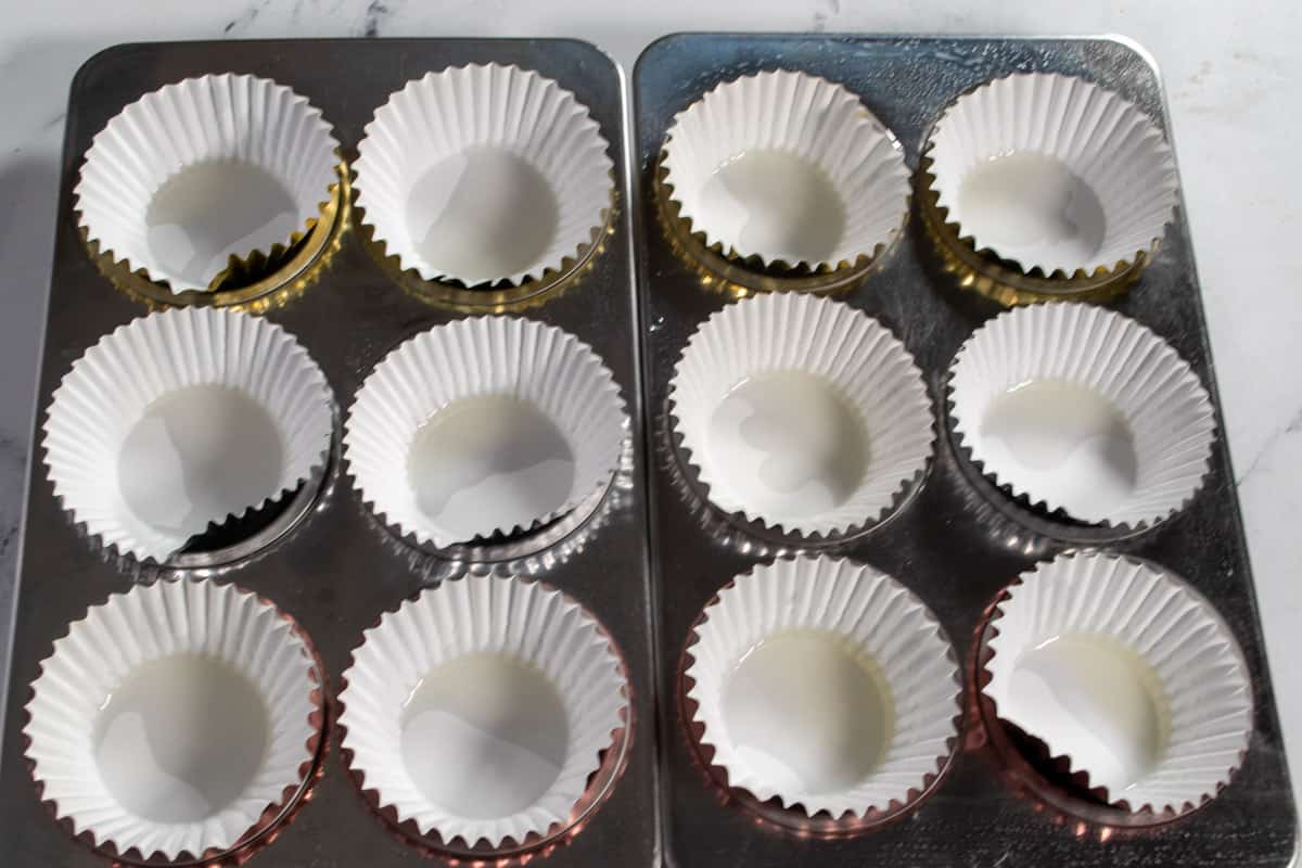 Two muffin trays lined with cupcake liners and greased. 