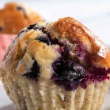 A close up photo of one of my vegan pistachio muffins with blueberries. The blueberries look super juicy.