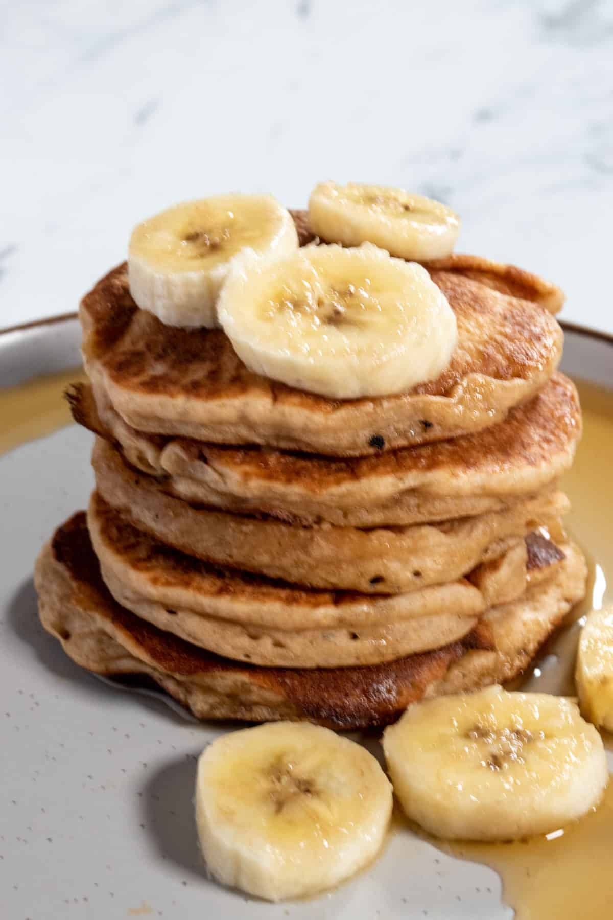 A shot of my vegan protein pancakes. Garnished with bananas and maple syrup.