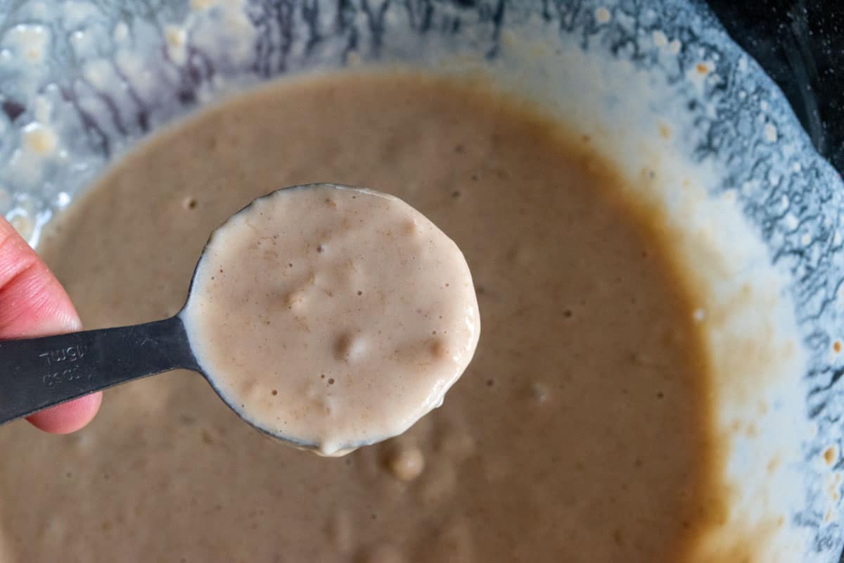 Vegan protein pancake batter in a measuring spoon. 