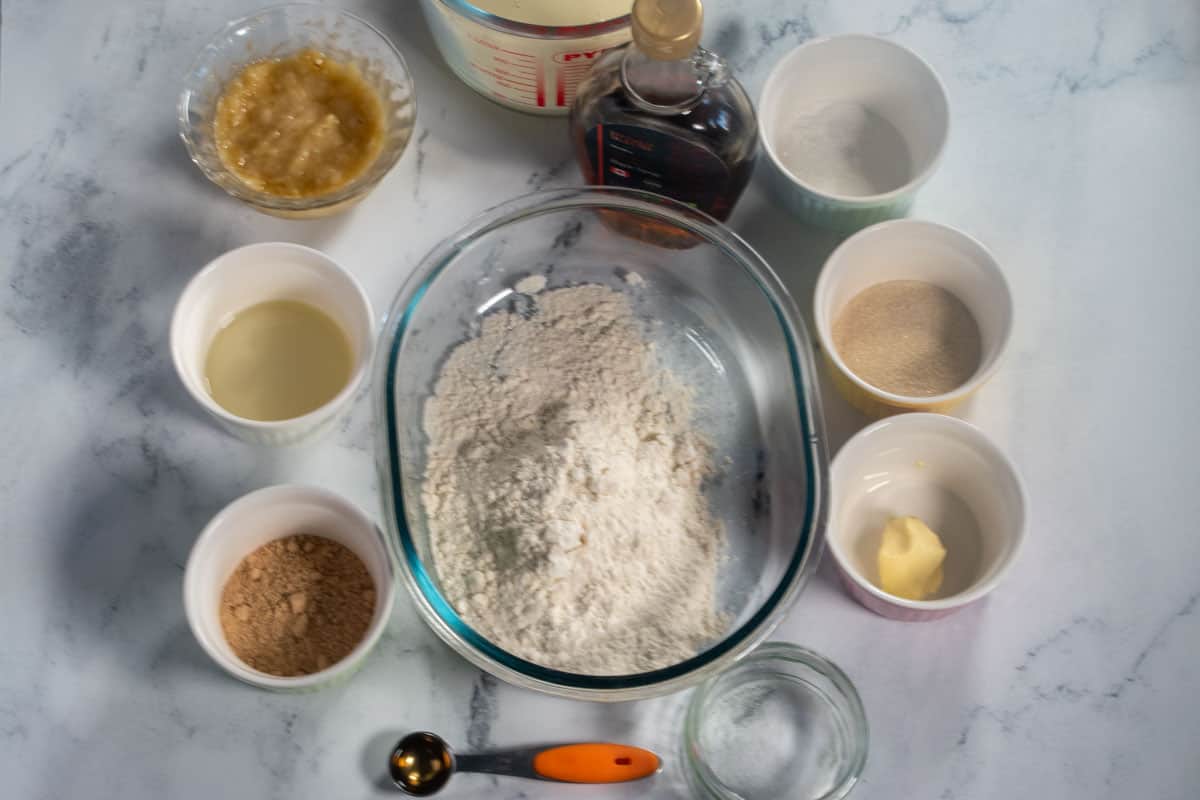 The ingredients needed for my vegan protein pancakes laid out neatly over a white, marble background.