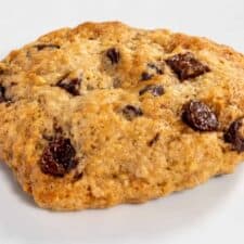 A large vegan banana chocolate chip cookie on a white plate.