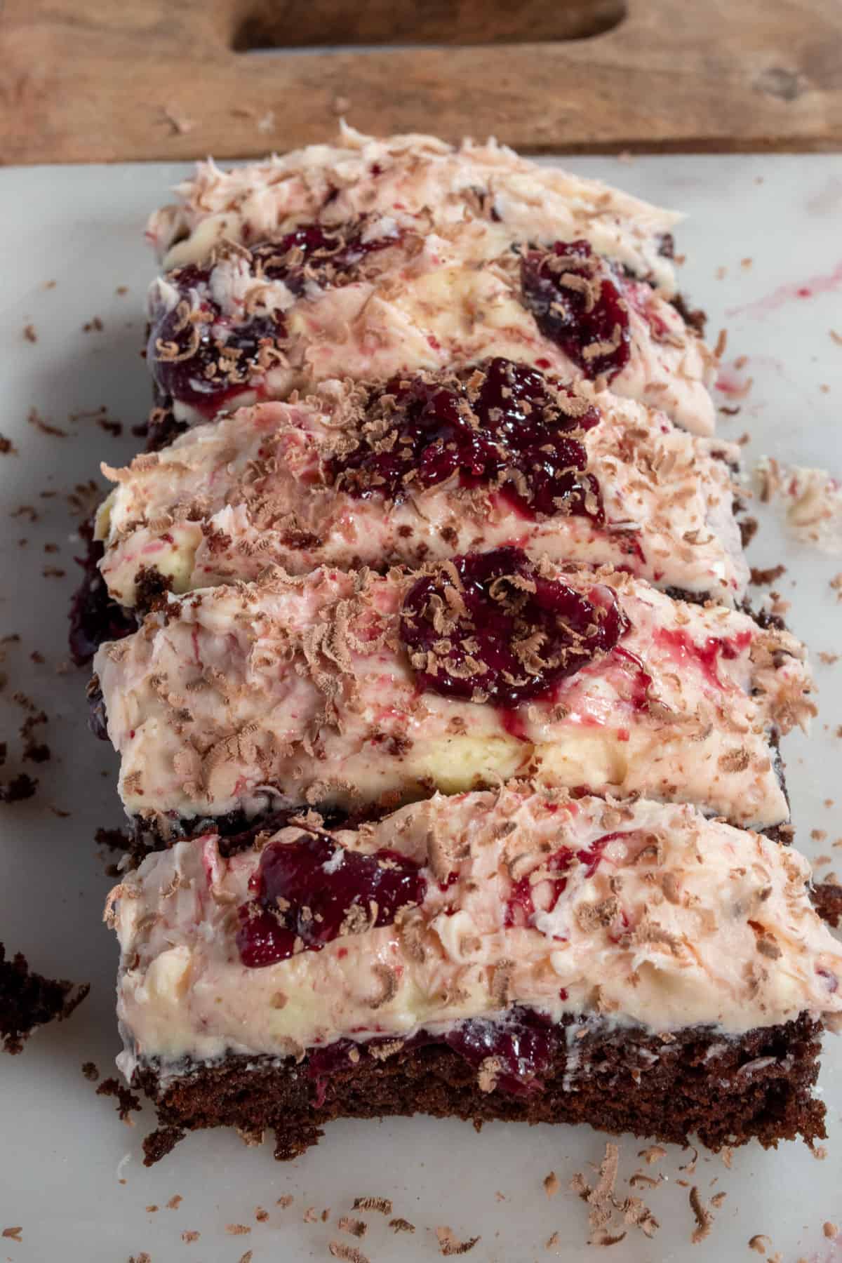 An overhead shot of my vegan black forest cake which is sliced into thick pieces. The cherry compote is glistening on top.