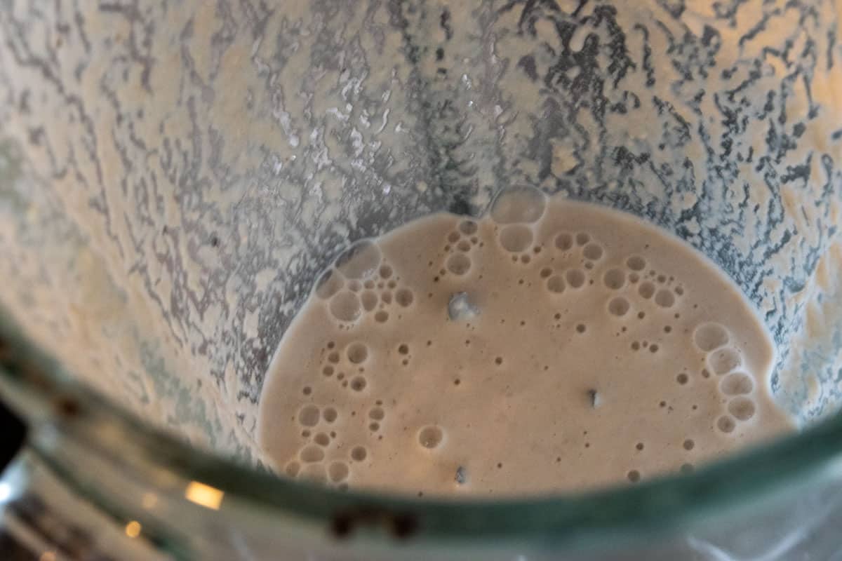 Cashew liquid inside a blender after being blitzed with water.