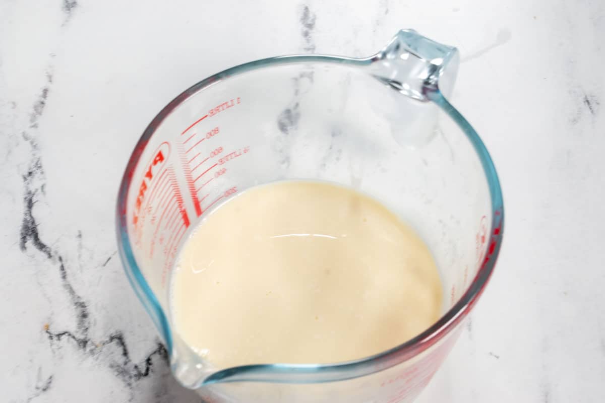 The soy milk in a measuring jug, curdling.