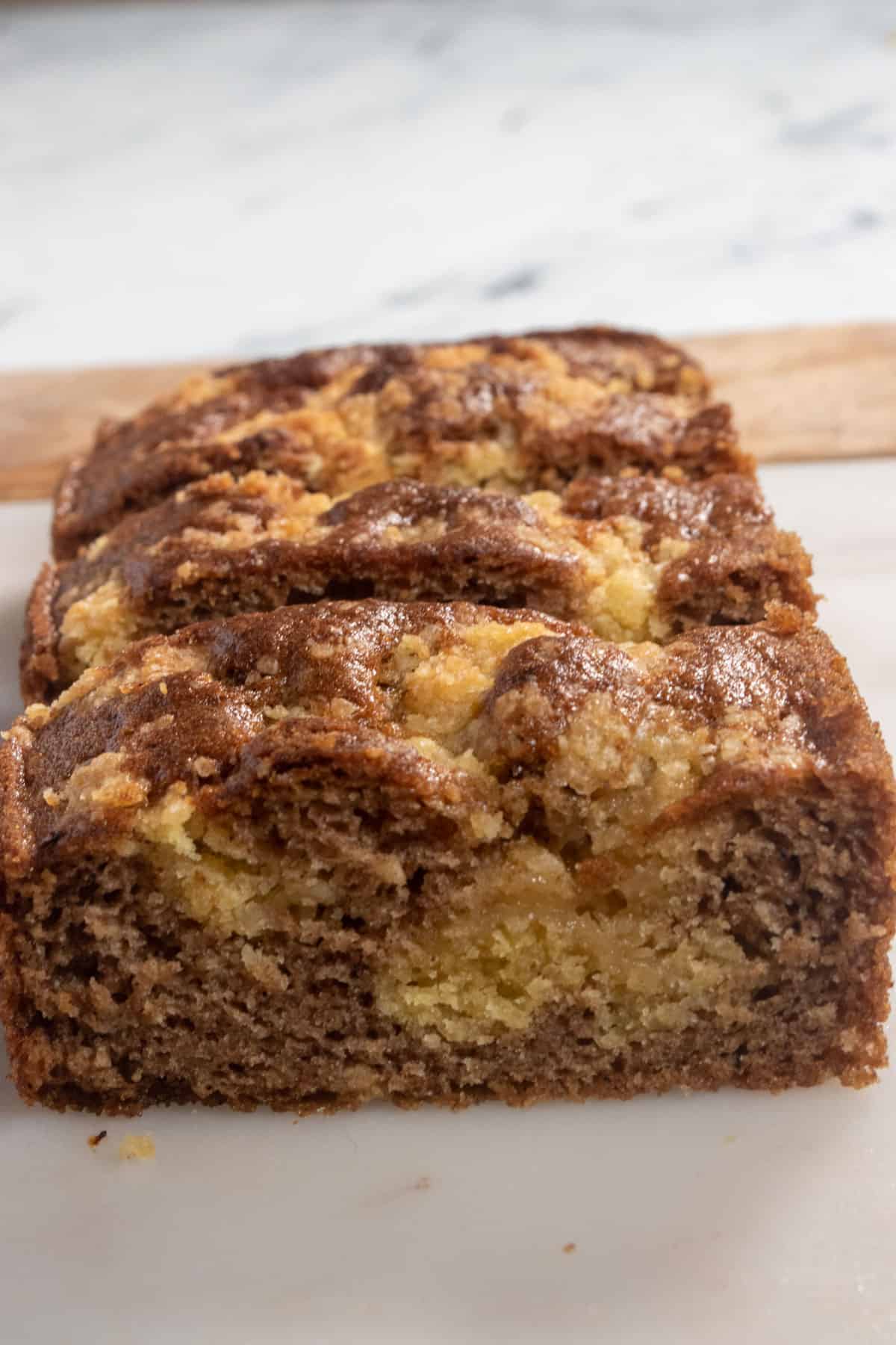 A whole cinnamon loaf cake with the front sliced off. It is moist and soft inside. 