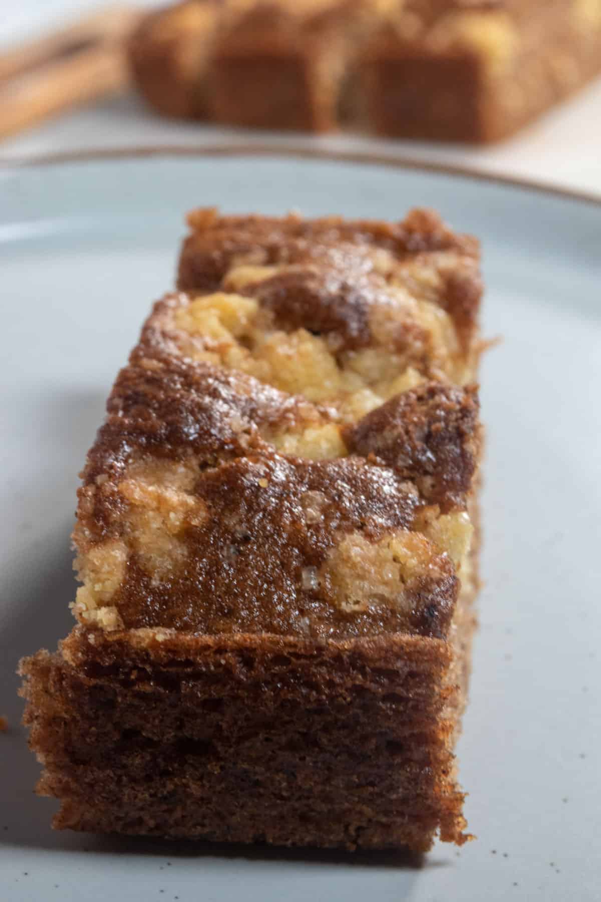 A side angled image of a slice of my vegan cinnamon cake. The streusel has created a 'marbling' effect on the top of the cake. 