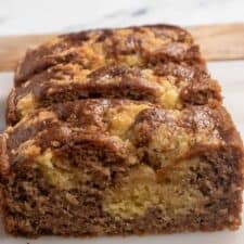 A loaf of my vegan cinnamon cake on a marble serving platter. The streusel has sunk into the cake.