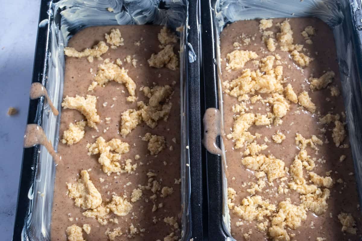 The cake tins are filled with the cake batter and topped with thick chunks of the streusel. 