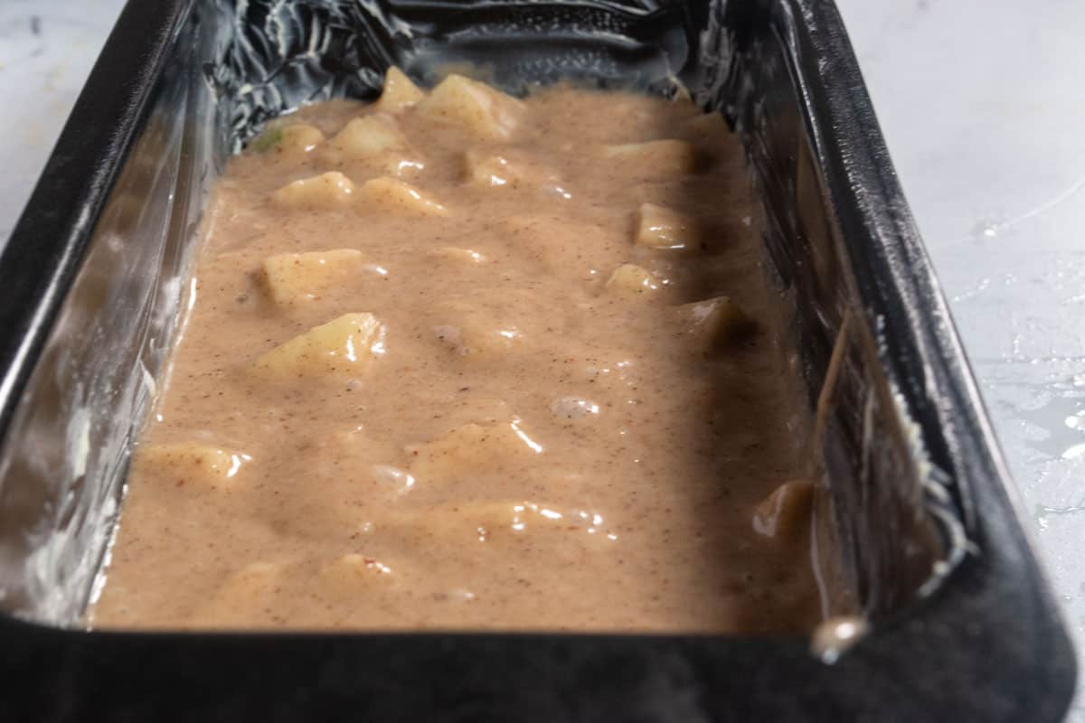 The vegan apple cinnamon cake batter has been poured into the cake tins. 
