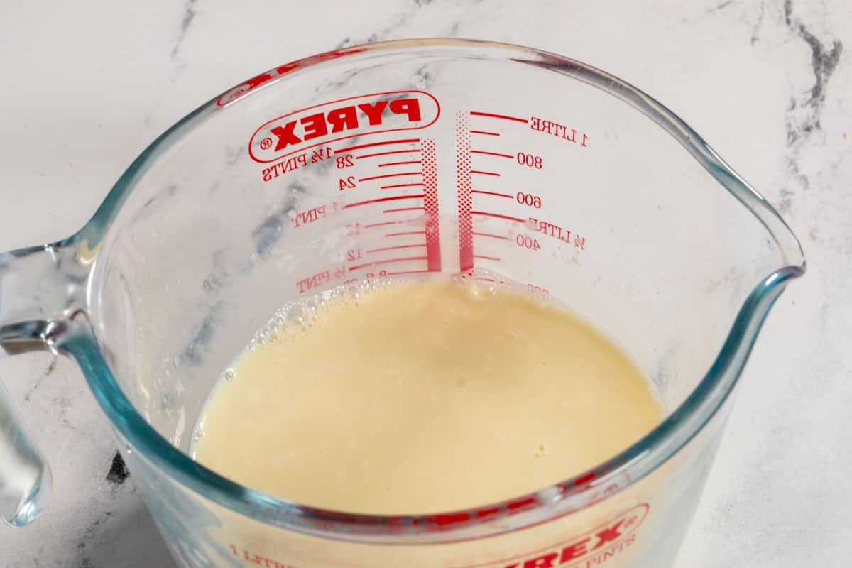 The vegan buttermilk for the cake, curdling inside a glass jug.