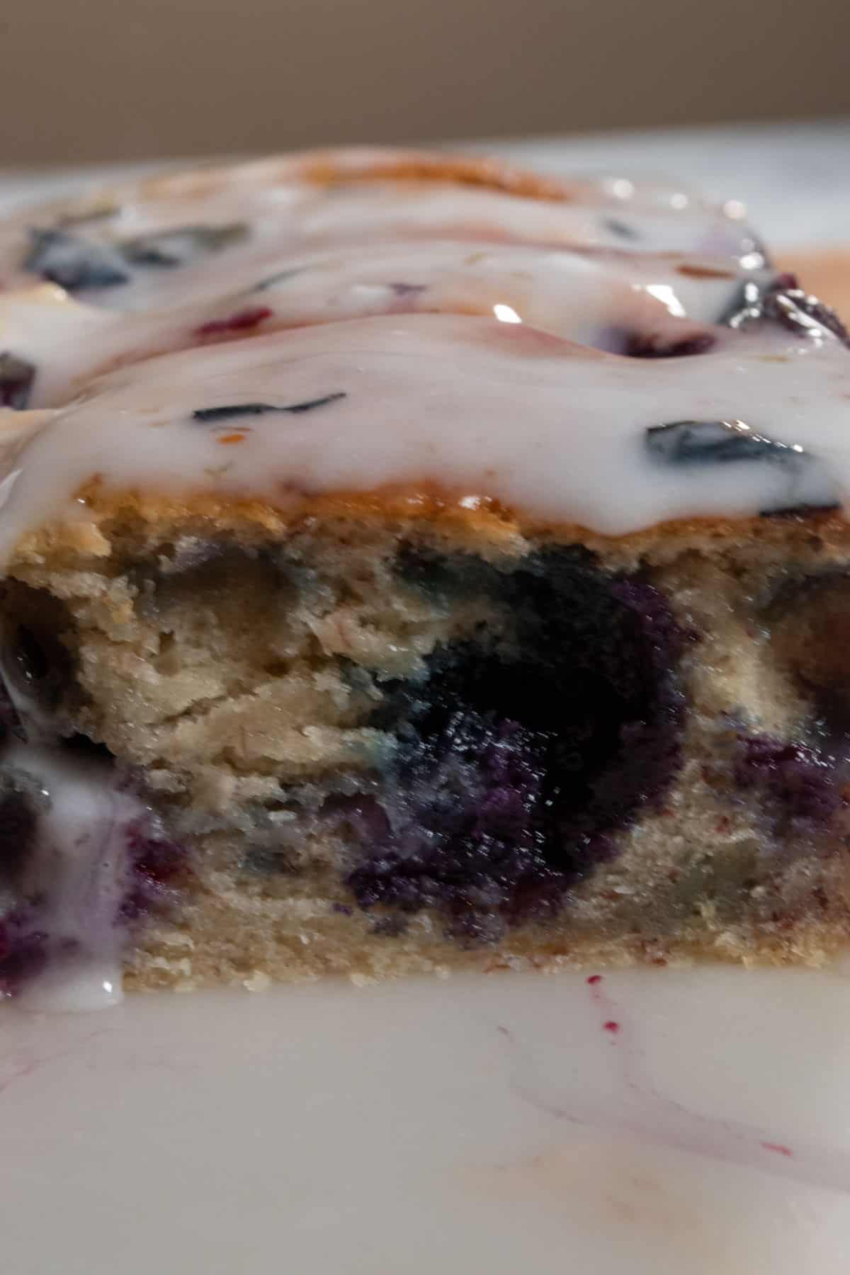 A zoomed in shot of a whole loaf of blueberry banana cake.
