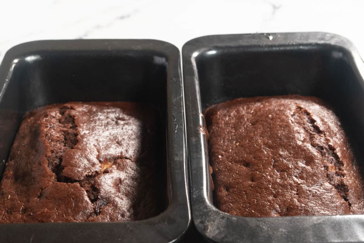 The two loaf cakes have been baked and are cooling in their tins. 