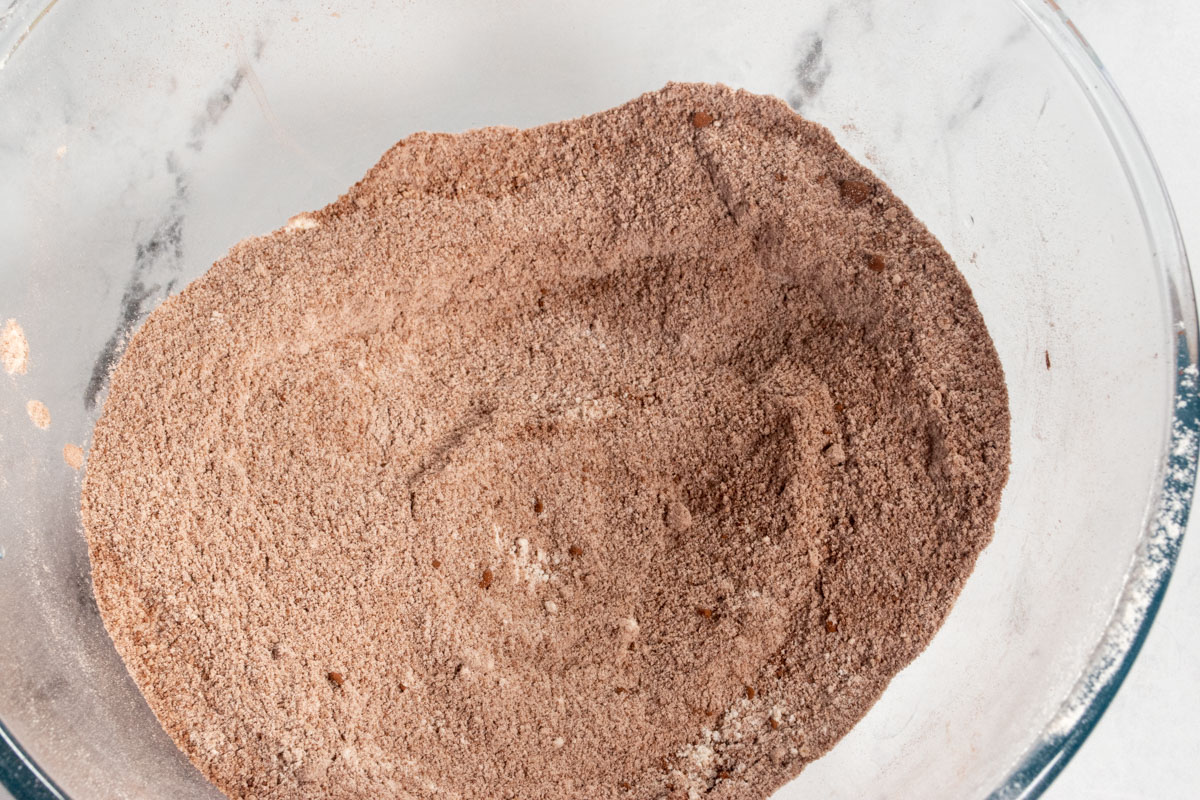 Dry chocolate cake ingredients mixed together inside a large bowl. 