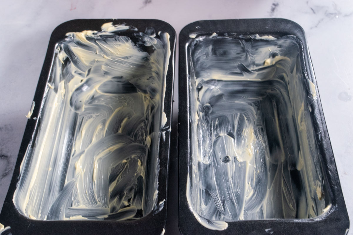 Two loaf cake tins greased with vegan butter.