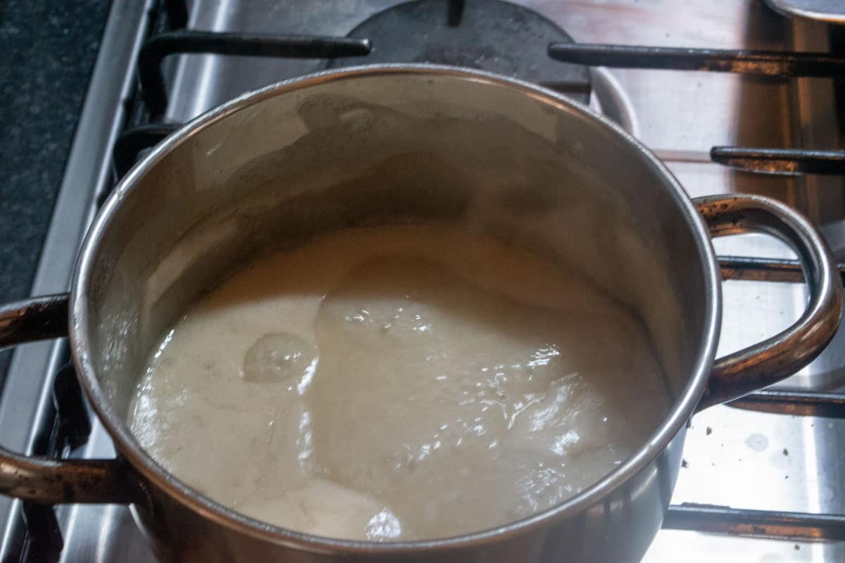 The vegan condensed milk is simmering and is a little browner now.