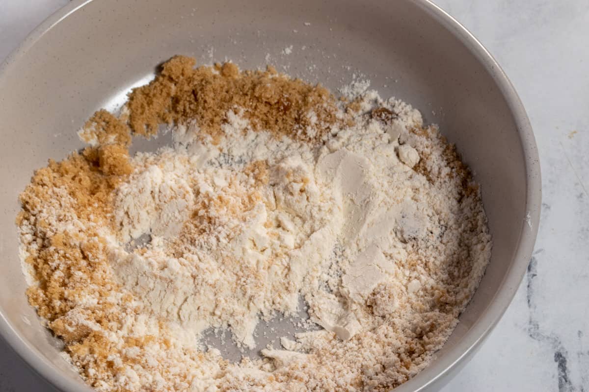 The flour and sugar for the streusel combined in a small, grey bowl. 