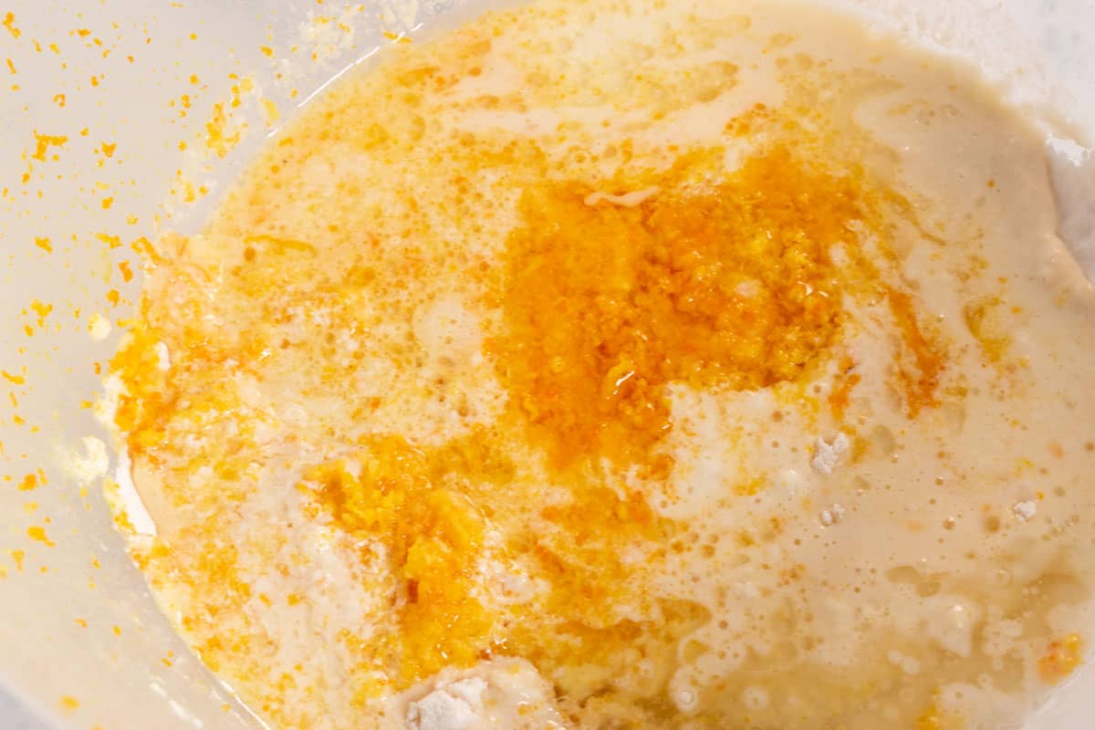 The wet ingredients including the orange juice and zest has been added to the mixing bowl.  