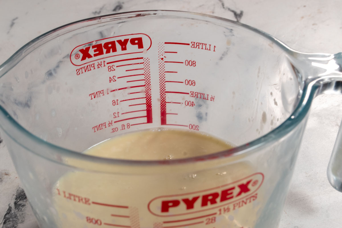 Vegan buttermilk curdling inside a glass jug. 