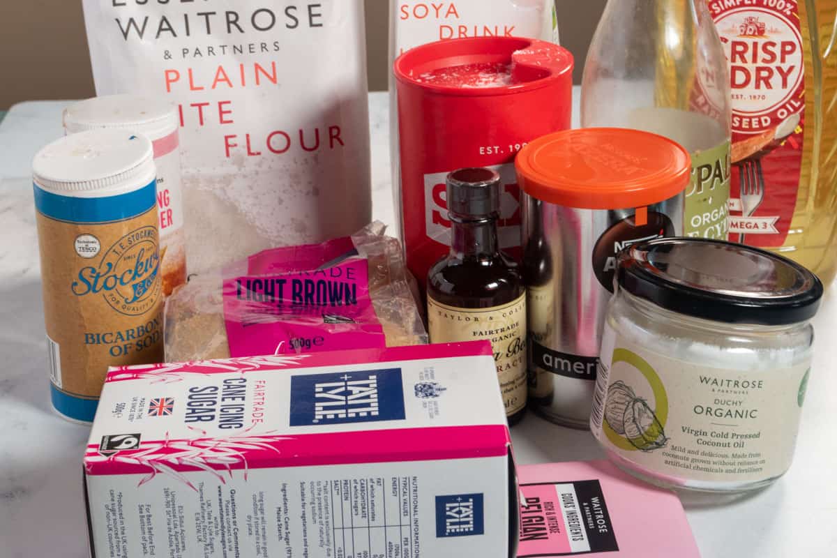 The ingredients needed to make a vegan mocha cake, laid out over a white, marble background.