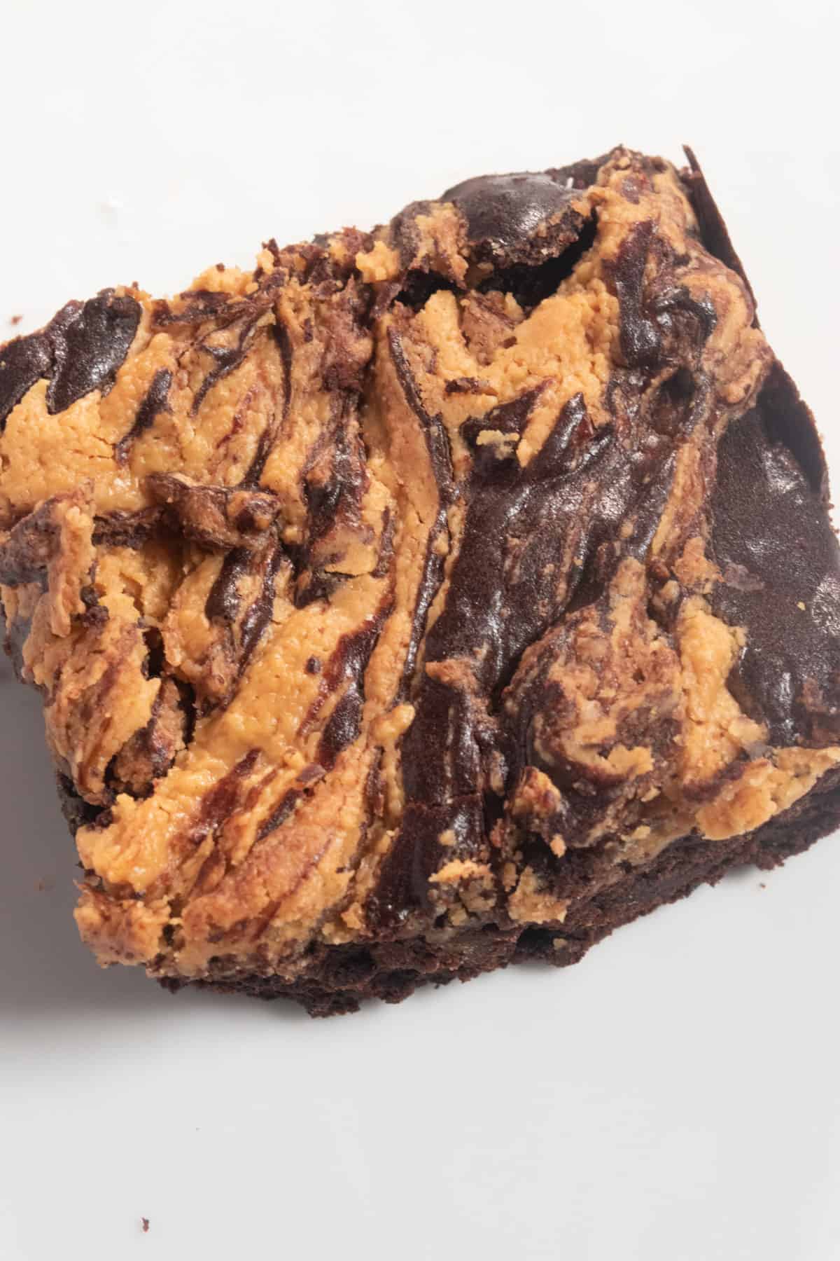 A single, large vegan peanut butter brownie. The peanut butter topping is a beautiful brown color.