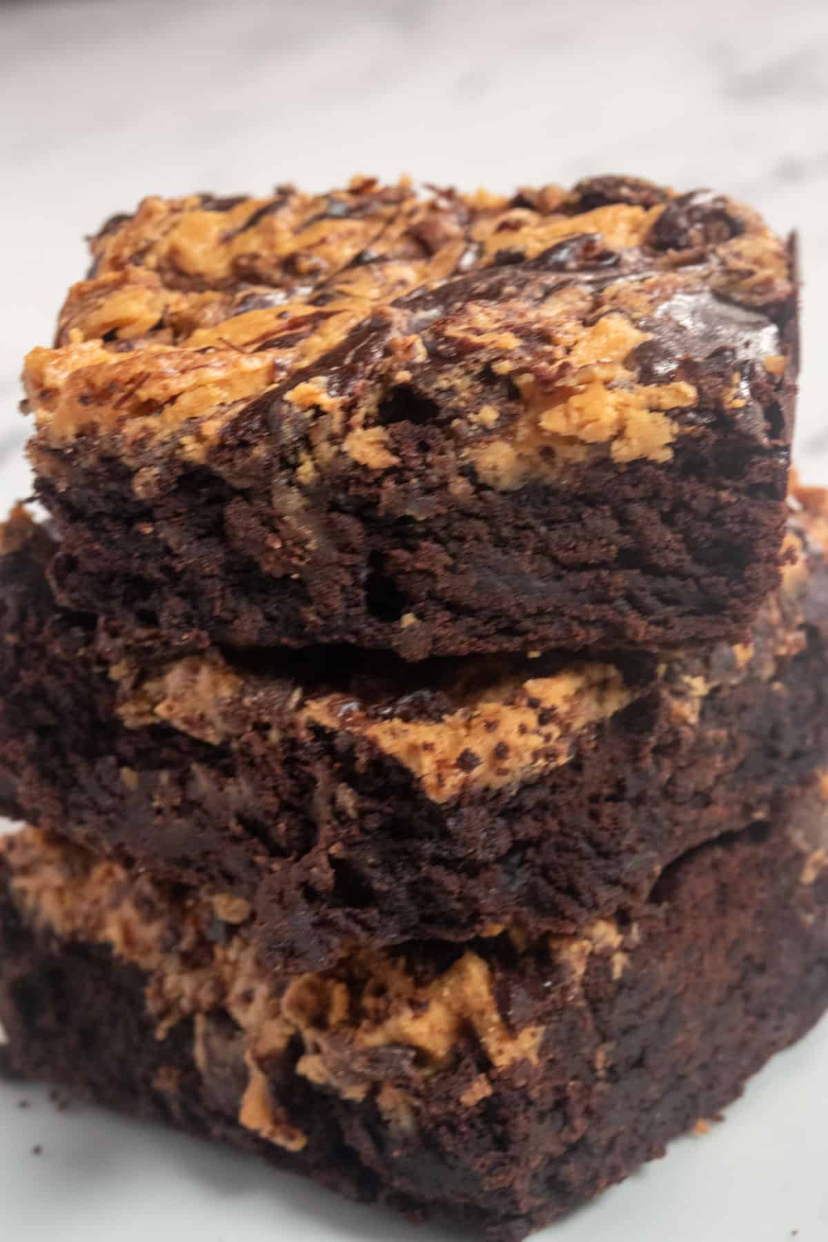 A stack of three vegan peanut butter brownies. They are all super chocolatey. 