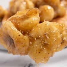 A spoonful of caramelized bananas being shown close up to the camera.