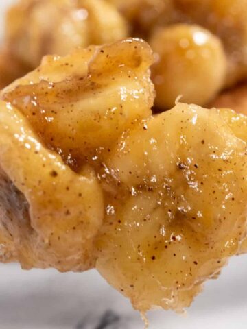 A spoonful of caramelized bananas being shown close up to the camera.