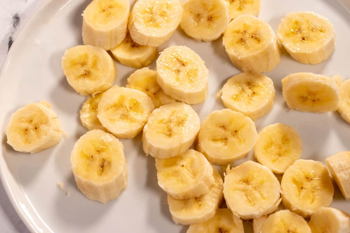 Chopped bananas on a white serving plate.