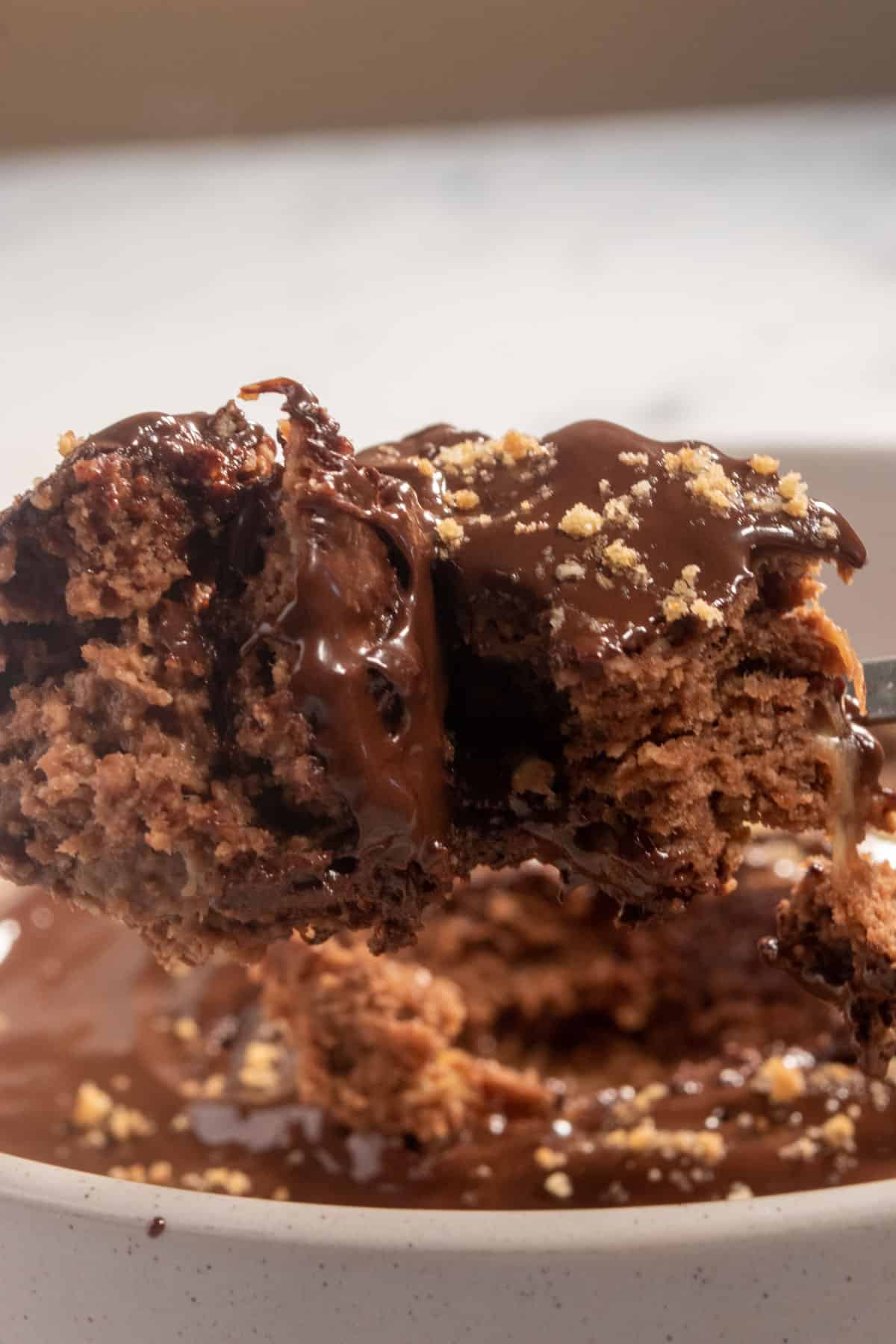 A heaped tablespoon of creamy chocolate baked oatmeal. It is covered with melted chocolate.